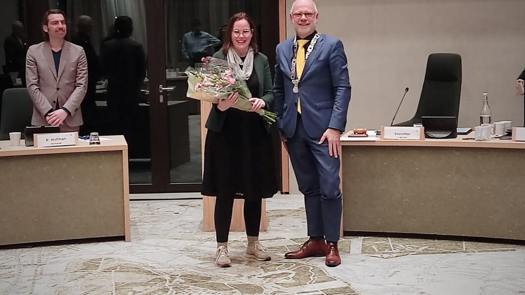 Suzanne vrieze ontvangt bloemen van de burgemeester