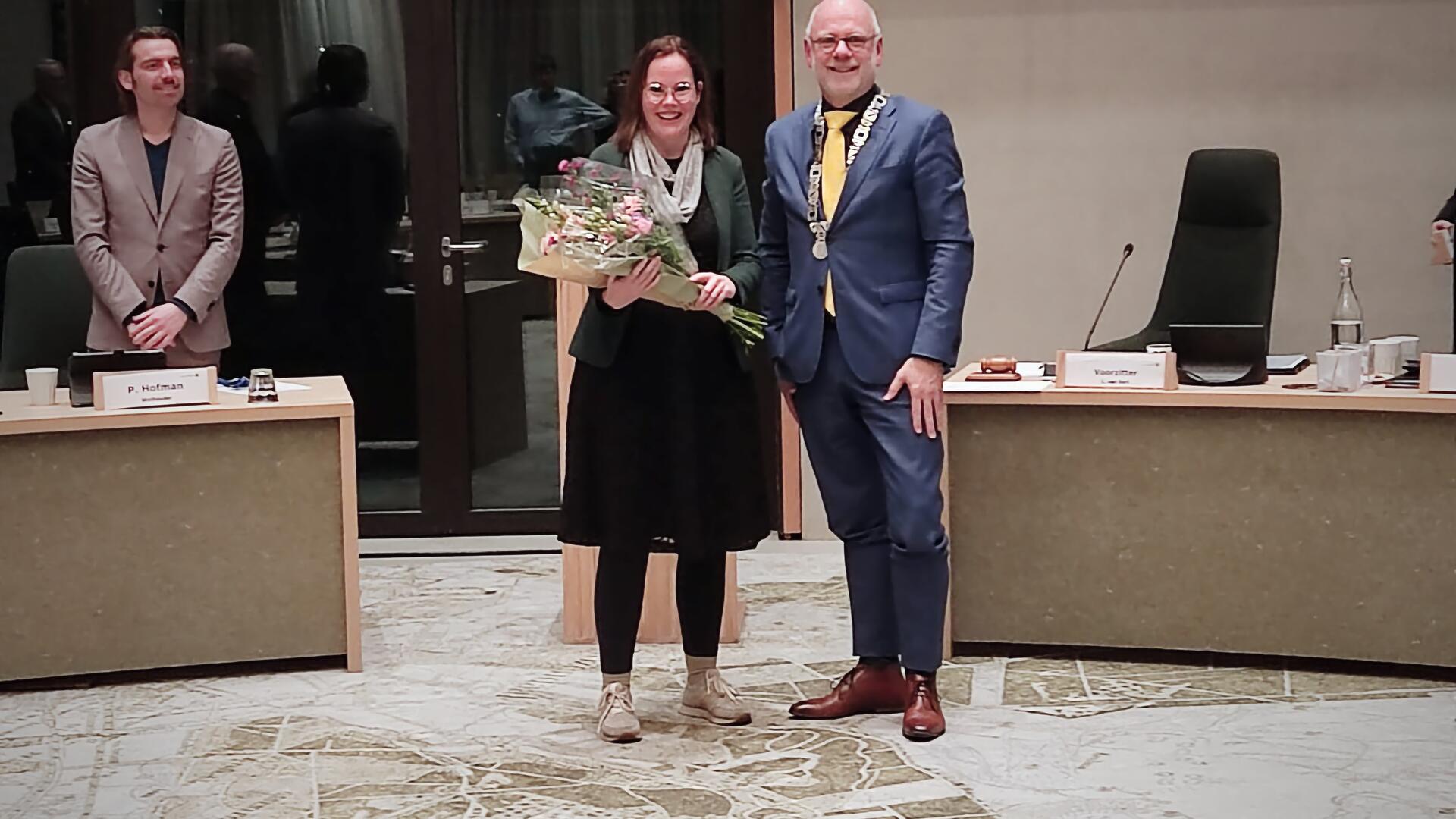 Suzanne vrieze ontvangt bloemen van de burgemeester