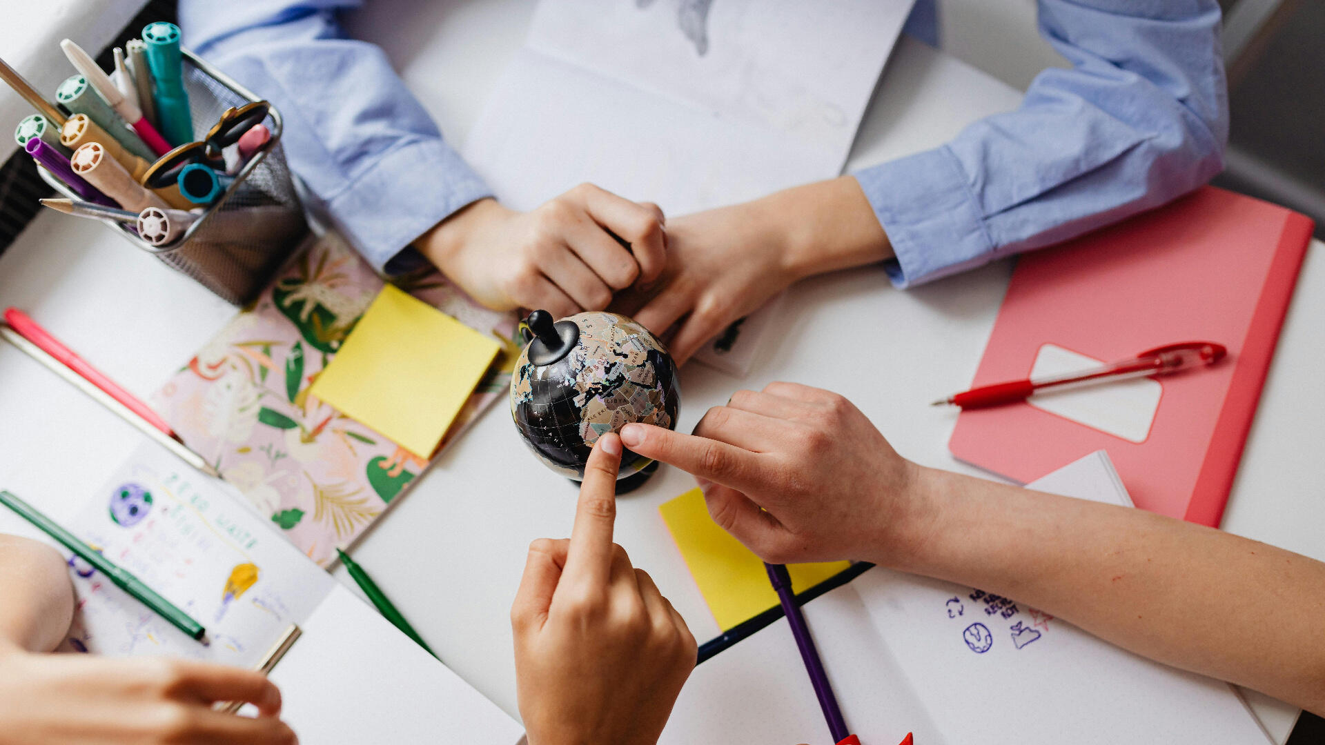 Kinderen wijzen naar een wereldbol